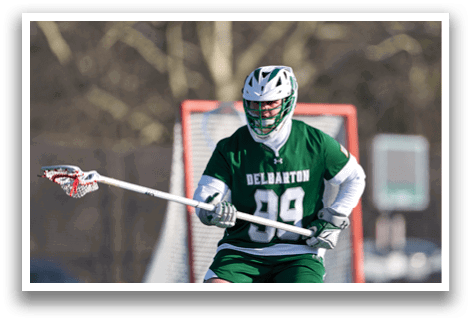 A man wearing a green and white uniform is holding a lacrosse stick and standing in front of a net. AI generated content
