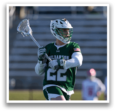 A man wearing a green and white jersey is holding a lacrosse stick and preparing to play. AI generated content