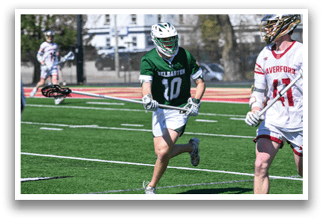 Two men playing lacrosse on a field. One is running with a stick. AI generated content