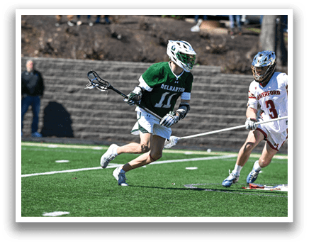 A man in a green and white uniform is running with a lacrosse stick, while another man in a red and white uniform is running towards him. They are both wearing helmets. AI generated content