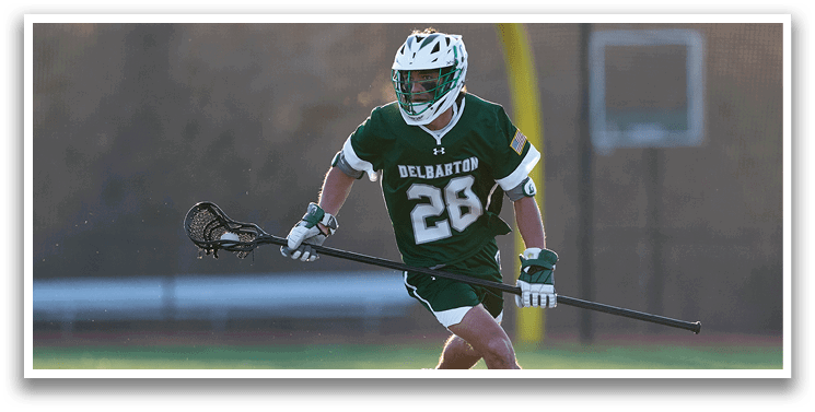 A man wearing a green and white uniform is running on a field while holding a lacrosse stick. AI generated content