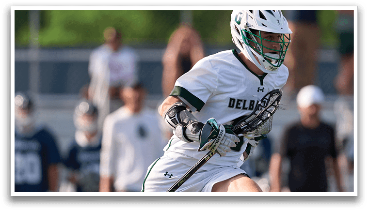 A man running on a field with a white helmet and green and white uniform. Description generated by AI