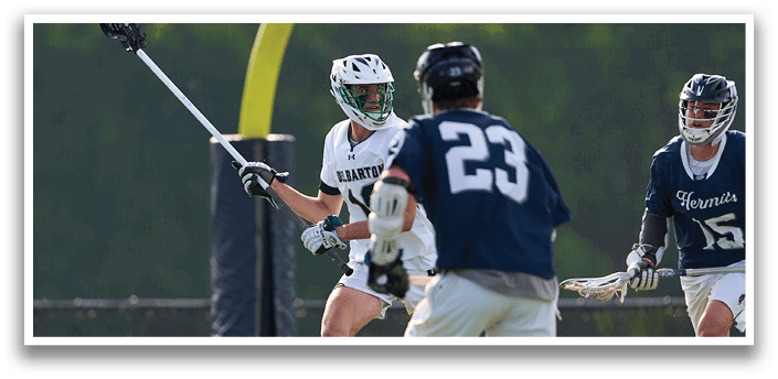 A group of men playing lacrosse on a field. Description generated by AI