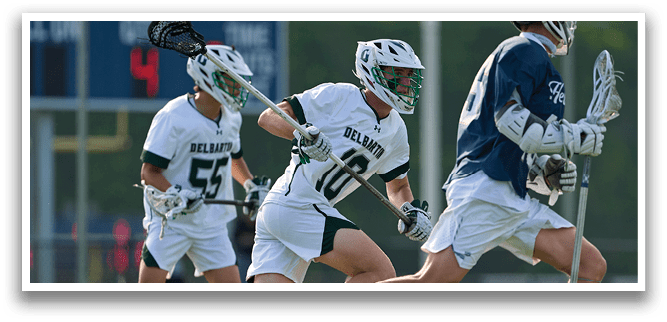 Three men playing lacrosse on a field. Description generated by AI