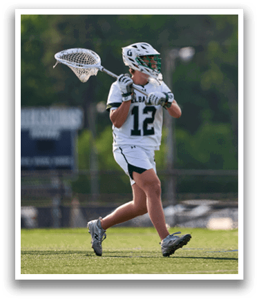 A man wearing a green and white uniform is running with a lacrosse stick. Description generated by AI