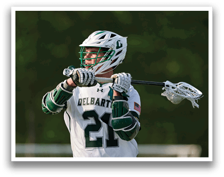 A man wearing a white and green jersey holding a lacrosse stick. Description generated by AI