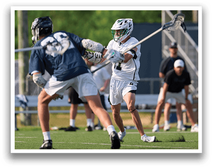 A man in a blue shirt and white shorts is playing lacrosse. Description generated by AI