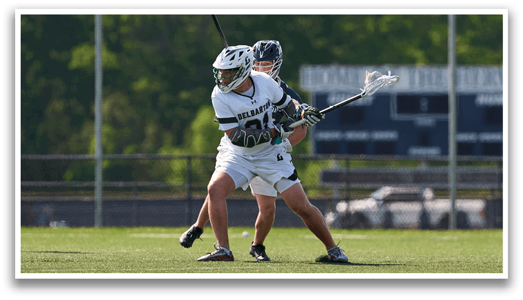 A man is playing lacrosse, holding a stick. Description generated by AI