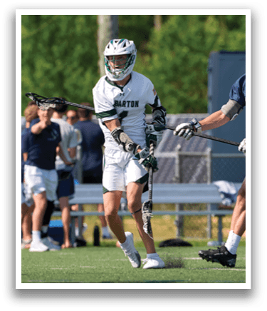 A man with a green helmet is playing lacrosse. Description generated by AI