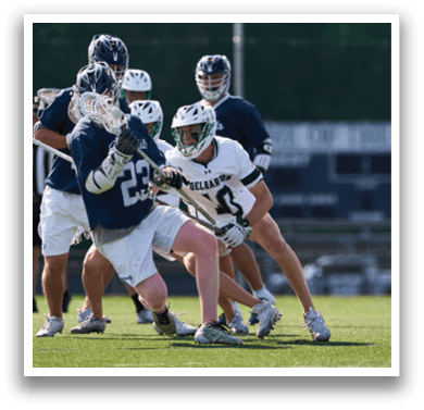A group of men playing lacrosse on a field. Description generated by AI