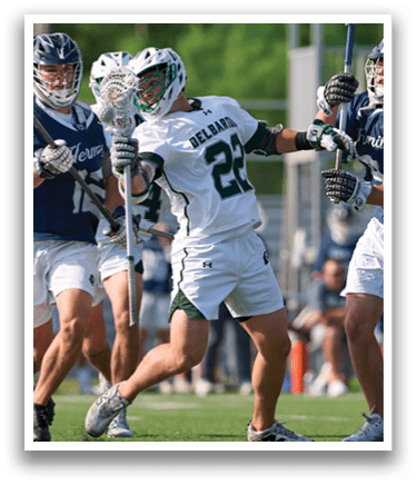 A group of men playing lacrosse on a field. Description generated by AI