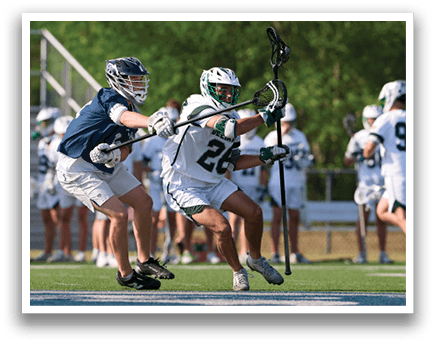 A man in a white jersey is holding a lacrosse stick. Description generated by AI