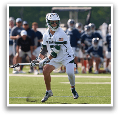 A man in a white and green uniform is playing lacrosse. Description generated by AI