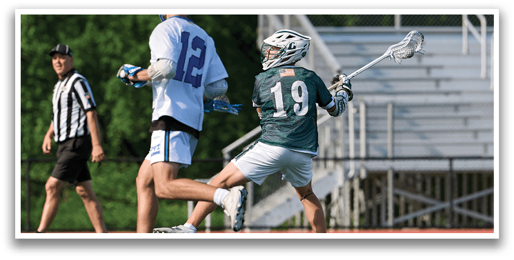 A man in a green shirt is running with a lacrosse stick. Description generated by AI