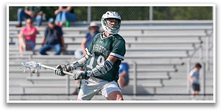 A man wearing a green and white uniform is running on a field. Description generated by AI