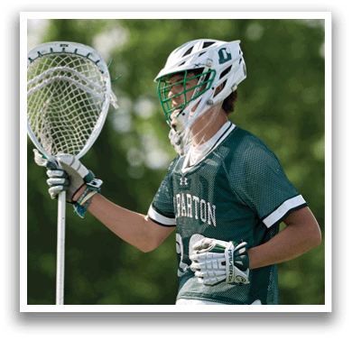A man holding a lacrosse net. Description generated by AI