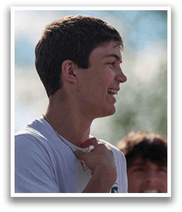 A man wearing a white shirt and a necklace. Description generated by AI