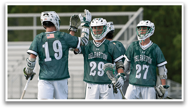 Three men wearing green jerseys and white shorts are holding their hands up. Description generated by AI