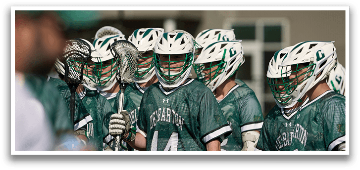 A group of lacrosse players wearing green and white uniforms. Description generated by AI