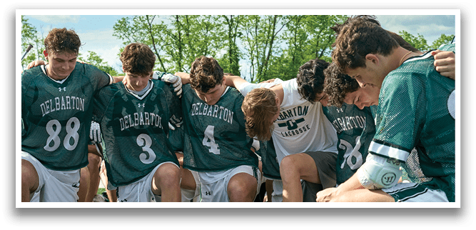 A group of people wearing green jerseys and white shorts. Description generated by AI