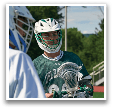 A man holding a lacrosse stick. Description generated by AI