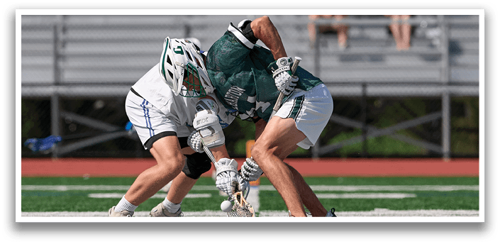 Two men playing a game of lacrosse. Description generated by AI
