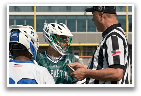 A referee is talking to a player in a green and white uniform. Description generated by AI