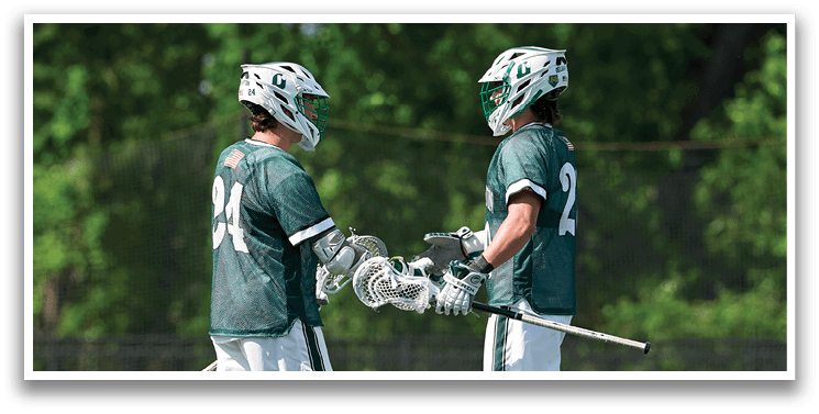 Two men wearing green shirts and white shorts are shaking hands. Description generated by AI