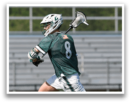 A man wearing a green and white shirt and white shorts is running with a lacrosse stick. Description generated by AI