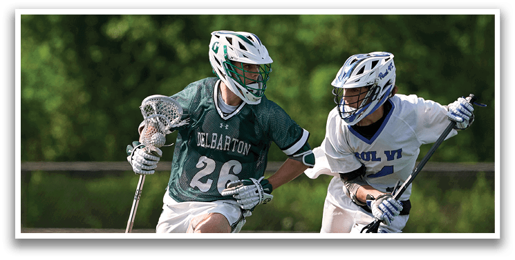 Two men playing lacrosse on a field. Description generated by AI