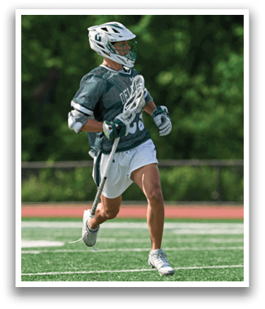 A man wearing a green and white shirt and white shorts is running on a field. Description generated by AI