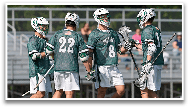 A group of men wearing green jerseys and white shorts are standing on a field. Description generated by AI