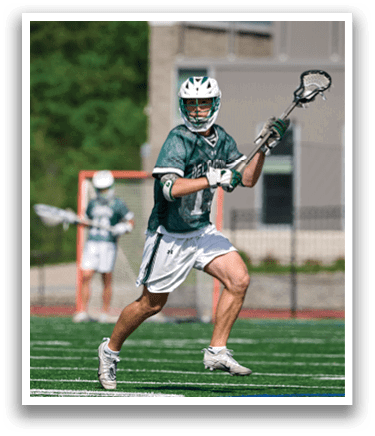 A man wearing a green shirt and white shorts is playing lacrosse. Description generated by AI