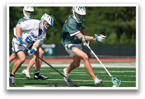 A man in a green and white uniform is holding a stick and running on a field. Description generated by AI