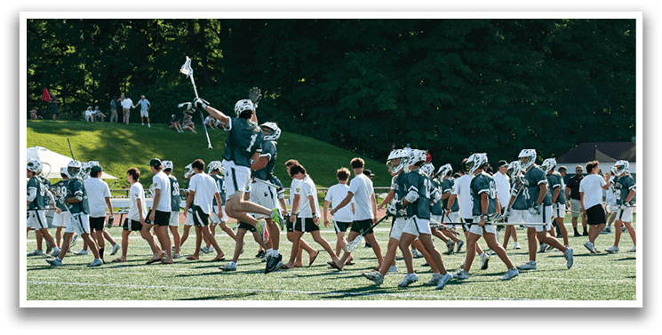 A man in a green shirt is running with a lacrosse stick. Description generated by AI
