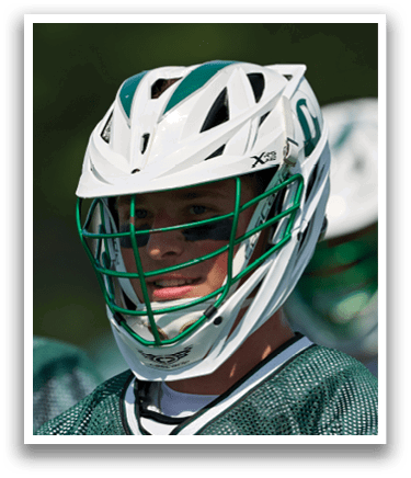 A man running on a field with a lacrosse stick. Description generated by AI