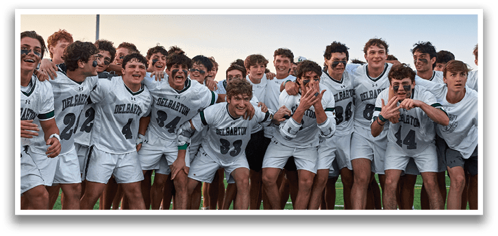 A group of lacrosse players wearing green and white uniforms. Description generated by AI