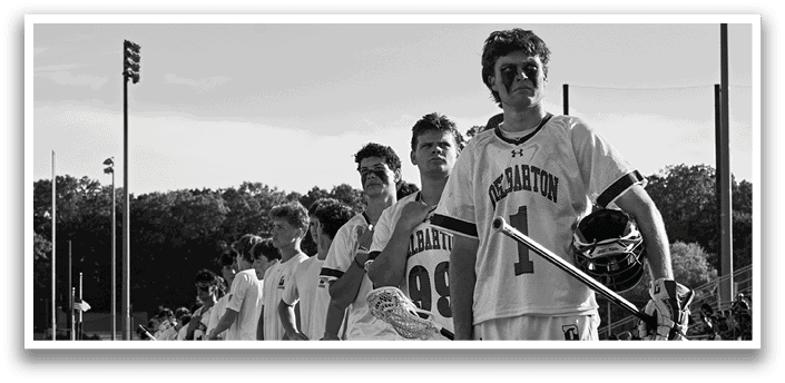 Two men playing a game of lacrosse. Description generated by AI