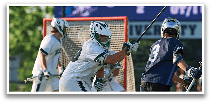 A man in a green shirt and white shorts is running with a lacrosse stick. Description generated by AI