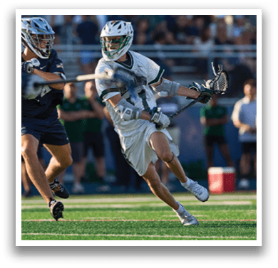 Two men wearing green jerseys and white shorts are standing on a field. Description generated by AI