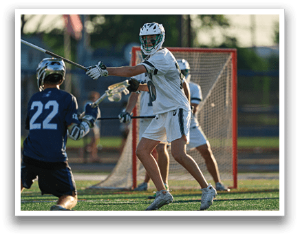 A person wearing a green and white shirt and holding a lacrosse net. Description generated by AI