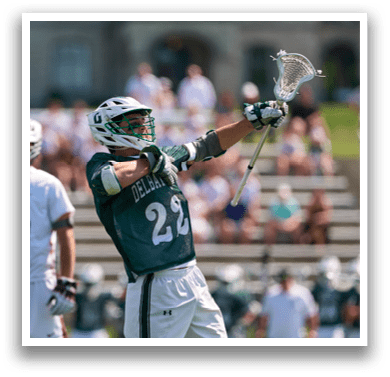 A man holding a lacrosse stick. Description generated by AI