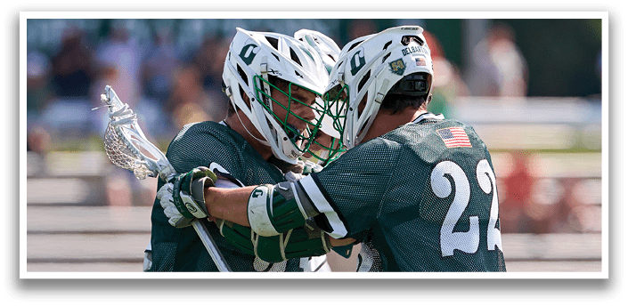 Two men playing a game of lacrosse. Description generated by AI