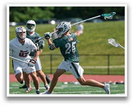 A man wearing a green and white shirt and white shorts is running with a lacrosse stick. Description generated by AI