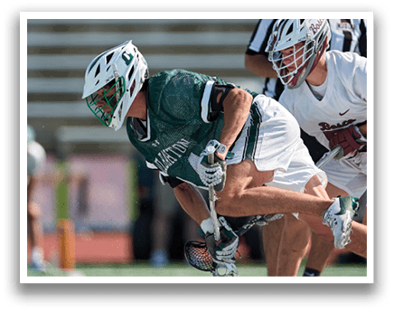 A person wearing a green and white shirt and holding a lacrosse net. Description generated by AI