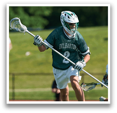 Two men wearing green jerseys and white shorts are standing on a field. Description generated by AI