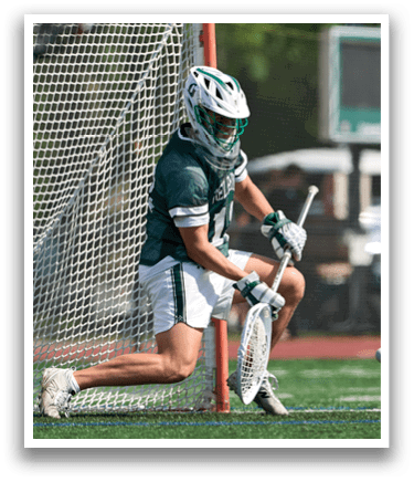 A man wearing a green shirt and white shorts is playing lacrosse. Description generated by AI