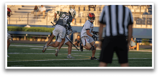A man in a green shirt and white shorts is running with a lacrosse stick. Description generated by AI