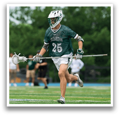 A man holding a lacrosse net. Description generated by AI