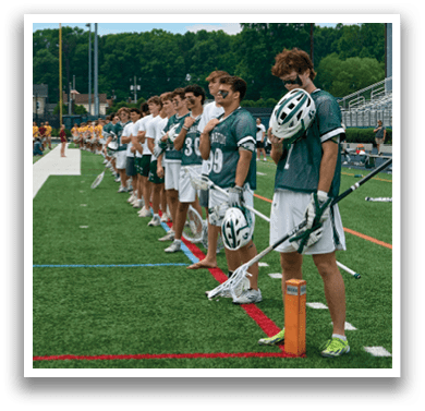 A man holding a lacrosse stick. Description generated by AI